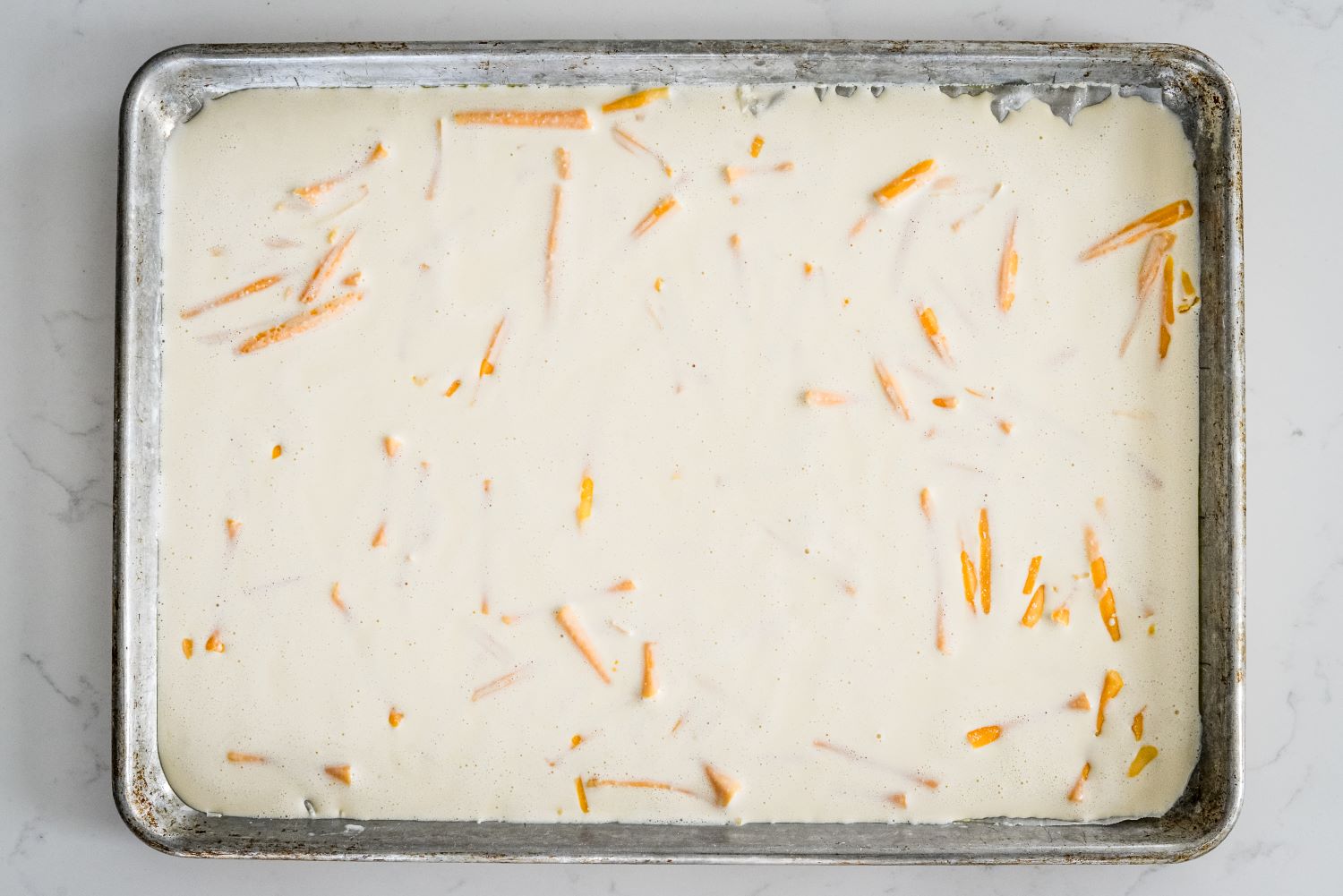 DMI_CottageCheeseWraps-4-(3).jpg cheddar cheese sprinkled evenly across sheet pan in cottage cheese batter